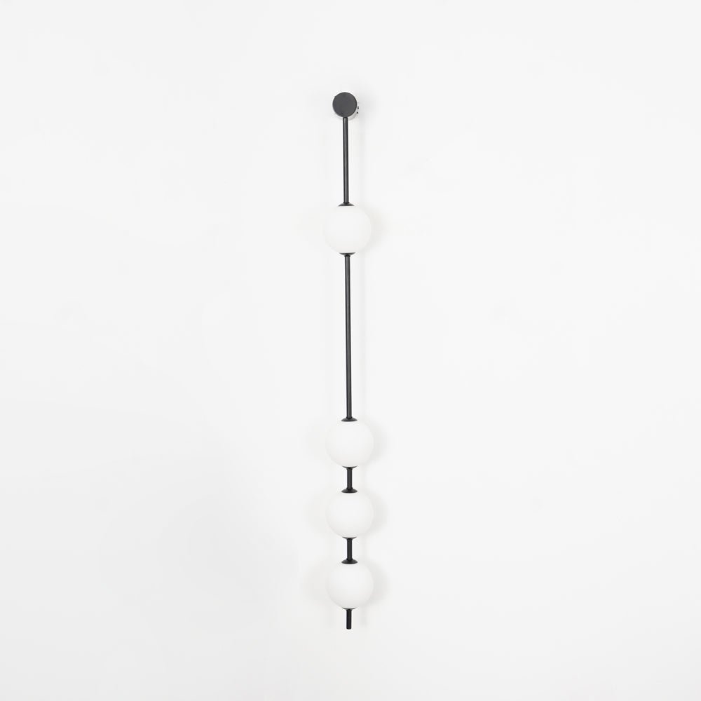 Wall lamp with a vertical row of white ball shades on a slim dark rod, unlit, on a white background.