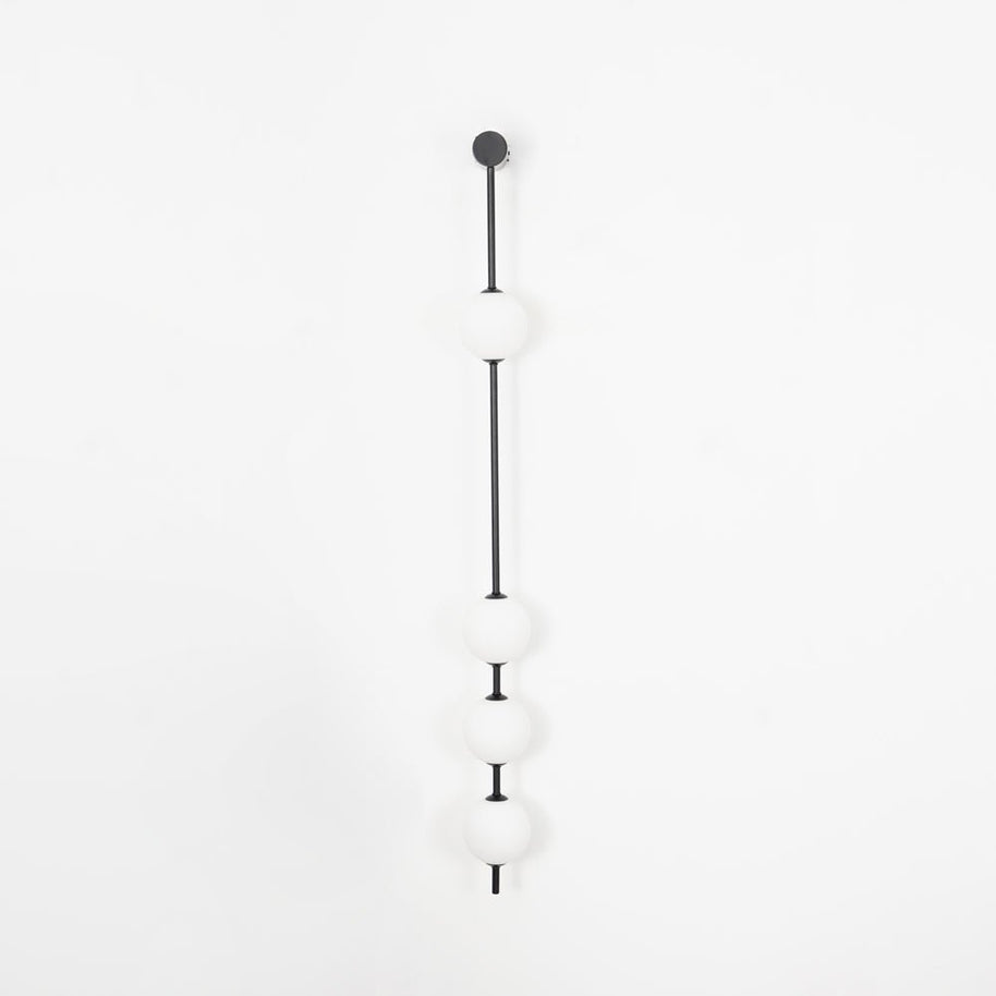 Wall lamp with a vertical row of white ball shades on a slim dark rod, unlit, on a white background.