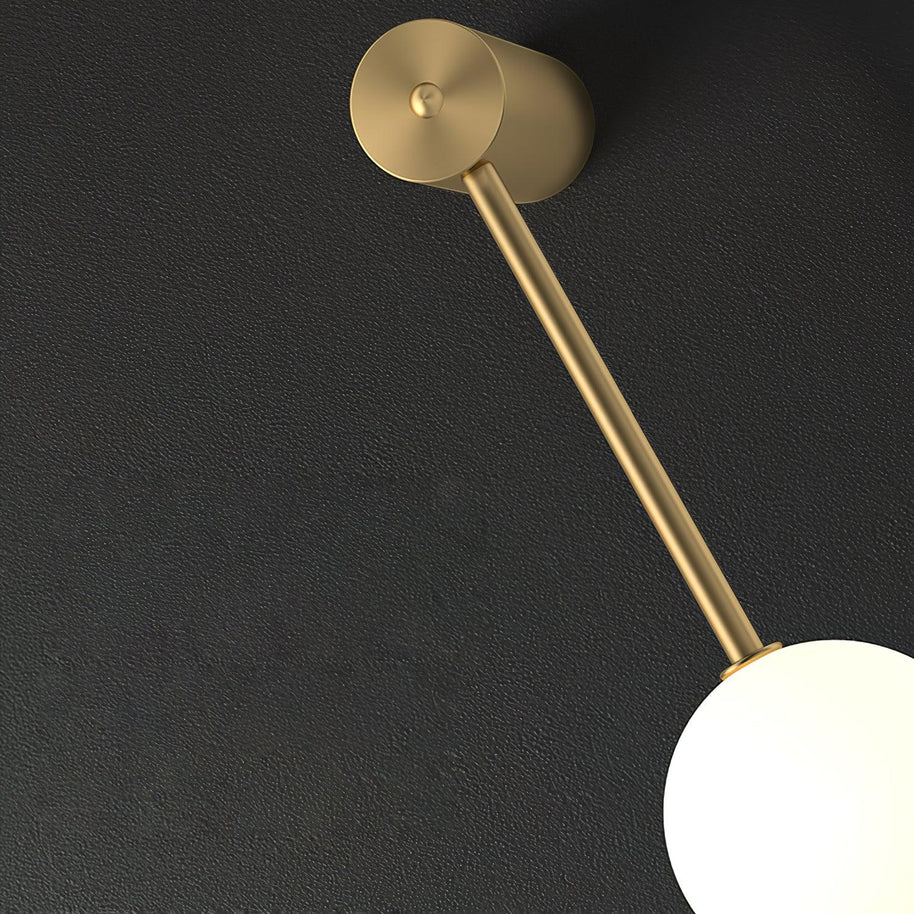 Close view of the brass-coloured top fitting, rod and one white ball shade.