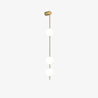 Wall lamp with a vertical row of white ball shades on a slim brass-coloured rod, unlit, on a white background, with a short row of shades.