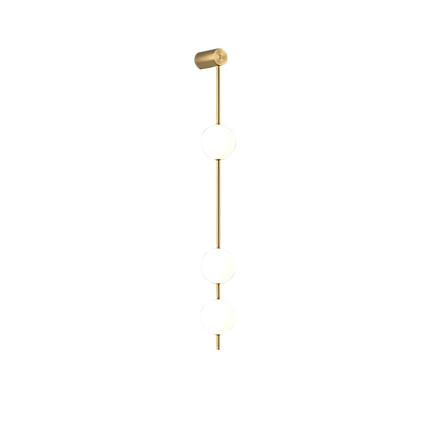 Wall lamp with a vertical row of white ball shades on a slim brass-coloured rod, unlit, on a white background.
