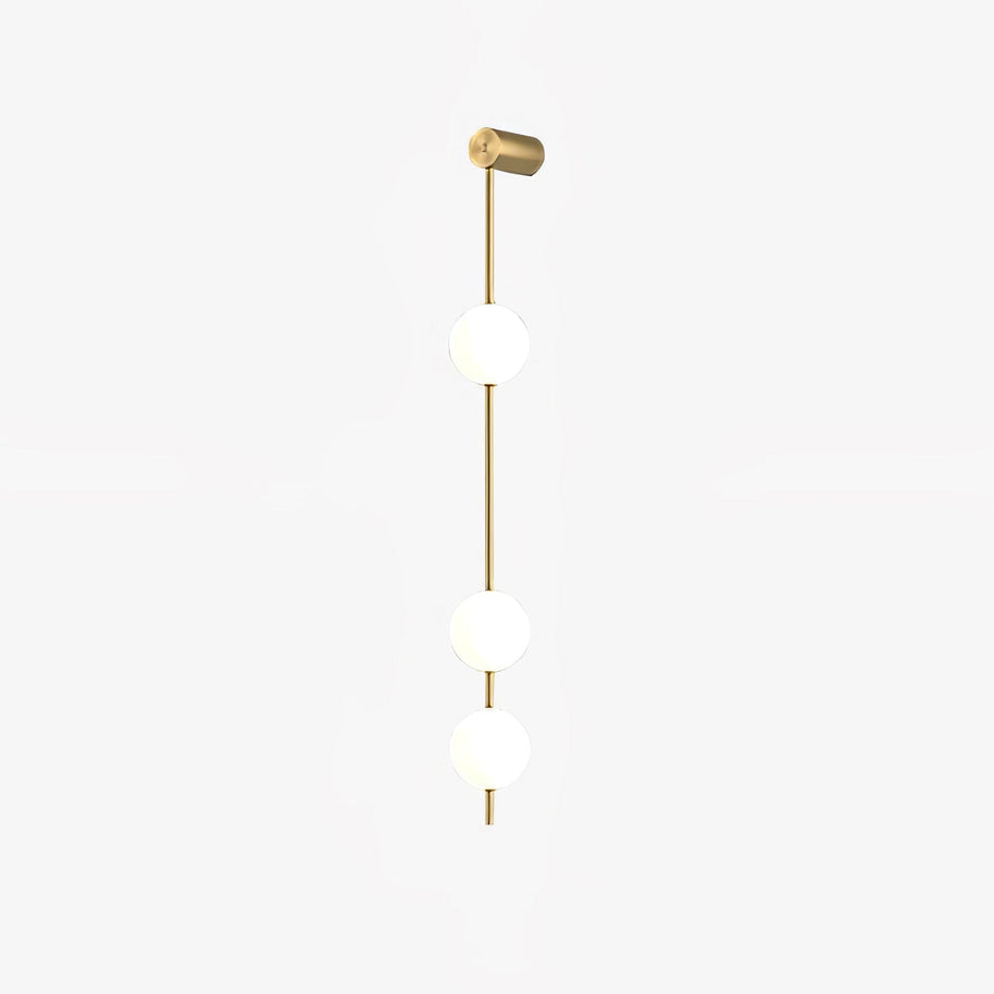 Wall lamp with a vertical row of white ball shades on a slim gold-toned rod, unlit, on a plain white background.
