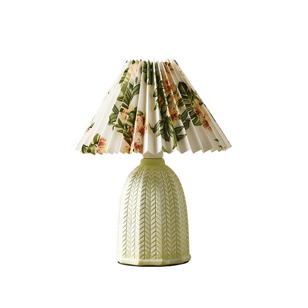 Table lamp with a white pleated shade in a printed floral pattern and a pale green ceramic base with a raised chevron pattern, shown on a white background.