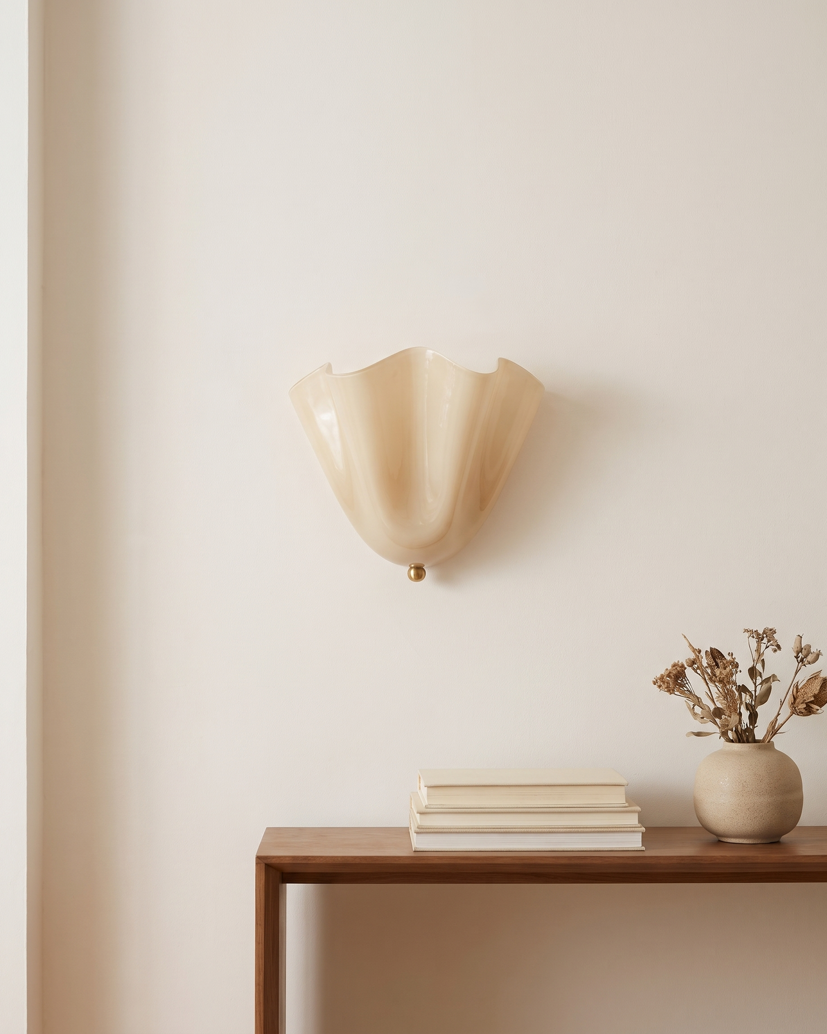 Vela Ribbed Glass Wall Lamp shown at scale above a console table