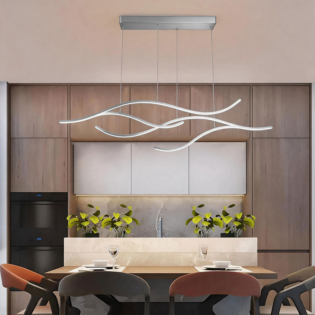 Linear pendant light made of wavy chrome-coloured LED bars hung from a slim rectangular canopy above a dining table in a wood-panelled room.