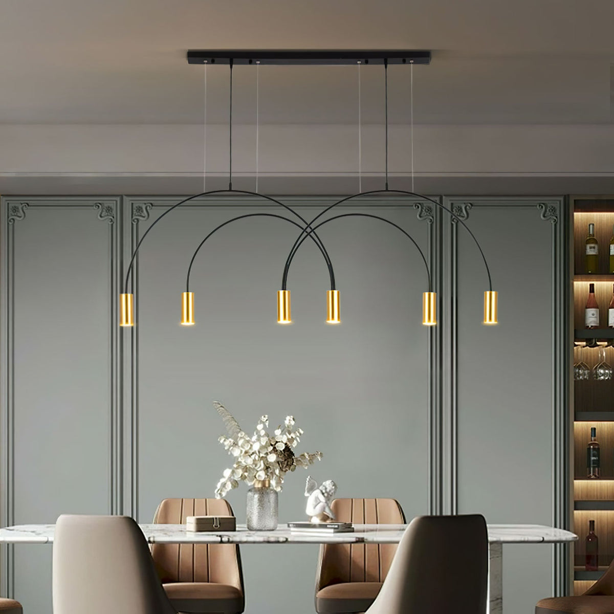 Arvelle Pendant Light with black arches and six gold heads, lit, above a marble dining table