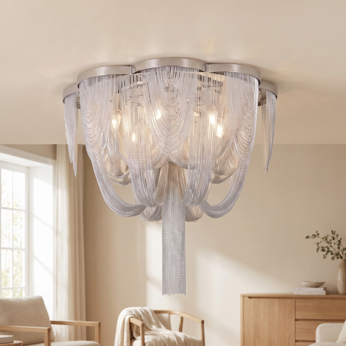 Cascenne Chain Tassel Ceiling Light: ceiling light made of a round polished silver frame with cascading draped silver chain strands forming a bowl, and a long silver chain tassel hanging from the centre, shown in a living room