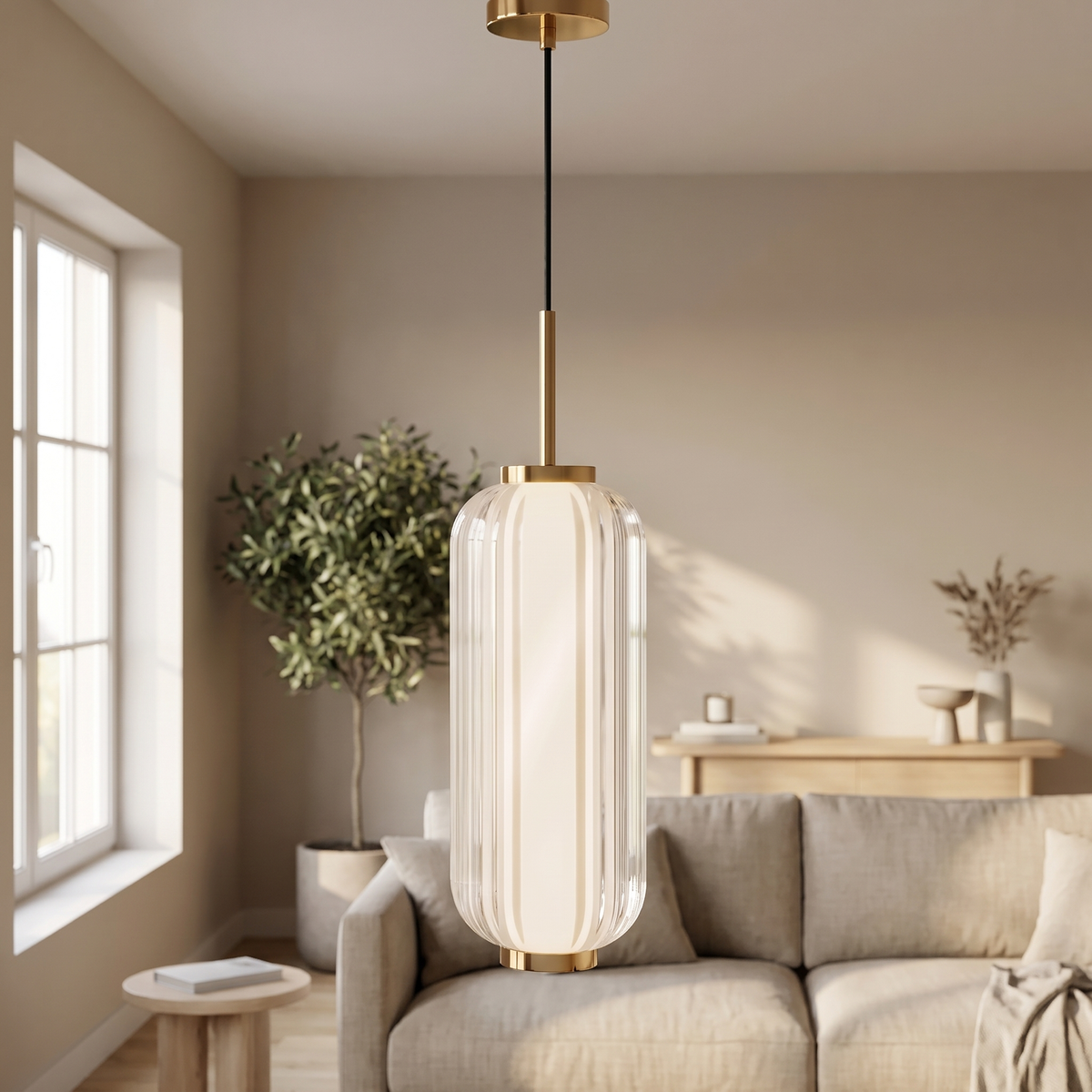 Fluvelle Striped Glass Linear Pendant: single tall cylindrical ribbed white glass lantern pendant with polished gold top and bottom caps, on a slim gold rod and black cord, shown in a living room