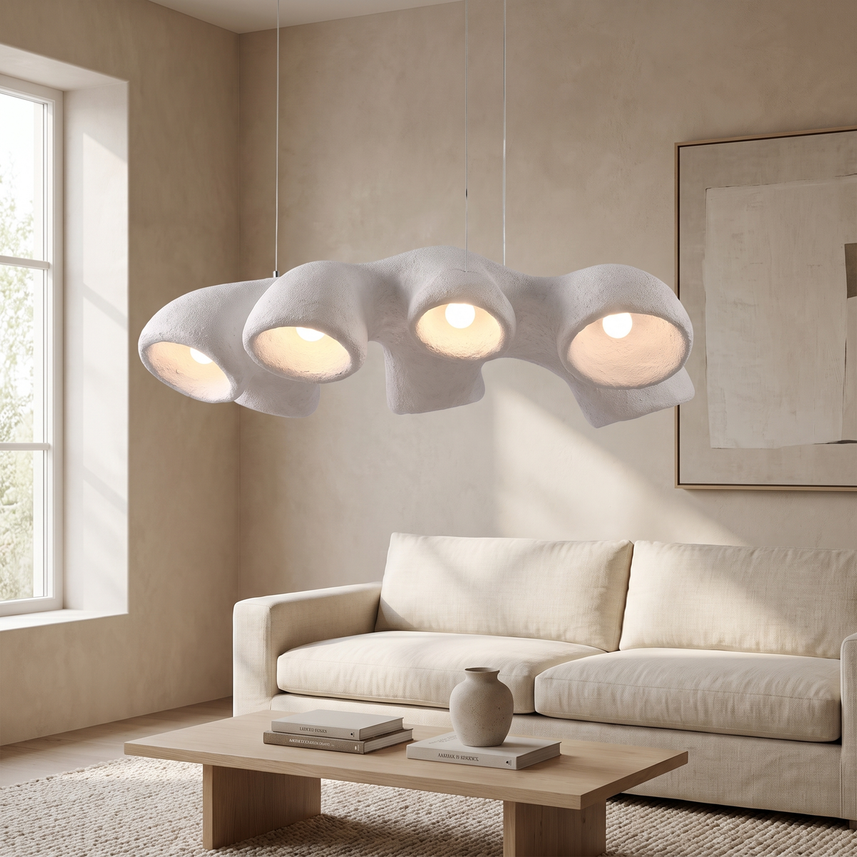 Nimbrae Sculptural White Pendant Light: sculptural organic pendant with a textured matte white body with 4 round light openings facing down, hung by 3 thin cables, shown in a living room