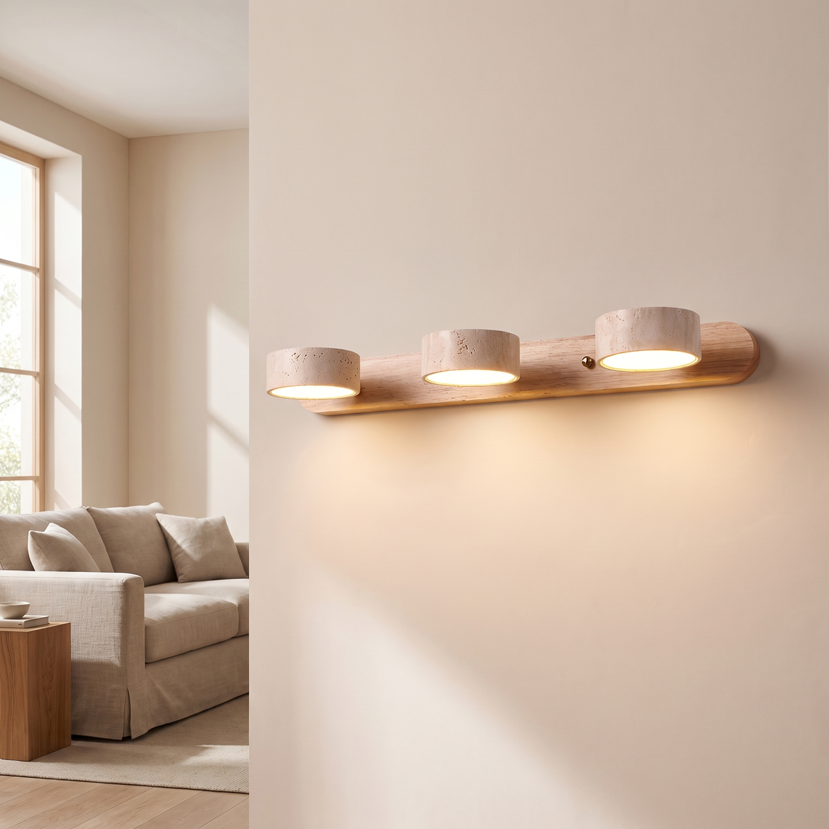 Moravine Travertine Rechargeable Wall Light: vanity wall light: a long horizontal light natural-wood bar with 3 round cream travertine cylinder lights along it, shown in a living room