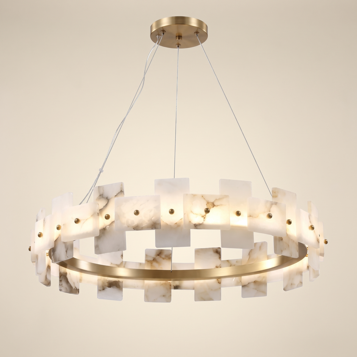 Zelvara Alabaster Ring Chandelier: round chandelier: a brushed antique brass ring lined with upright rectangular white alabaster panels with natural grey veining, hung by 3 thin cables