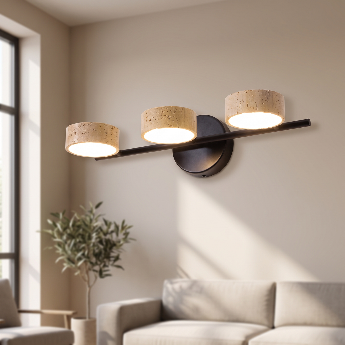 Yvessa Travertine Beam Vanity Light: vanity wall light: a slim black horizontal bar on a round black wall mount with 3 cylindrical yellow travertine shades sitting on the bar, shown in a living room