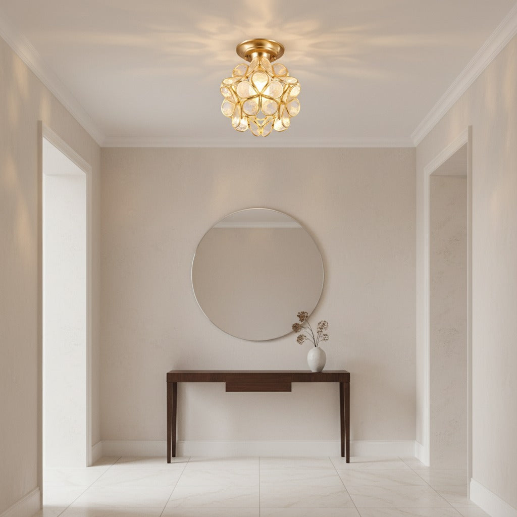 Aurisse Bloom Ceiling Light in clear and brass, lit, in an entry hall above a walnut console table