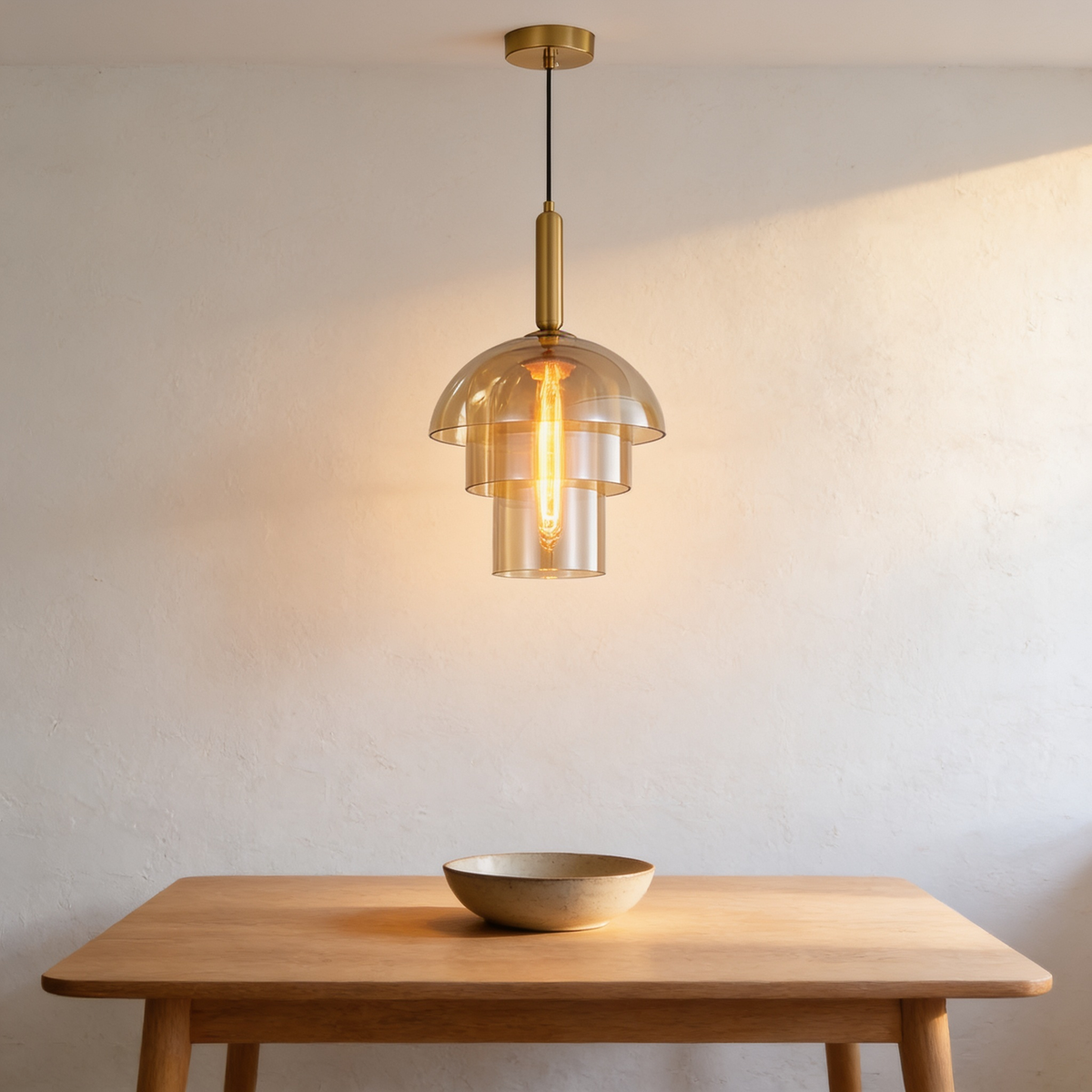 Jovelle Pendant Light with amber glass tiers and a brass stem above a wooden table