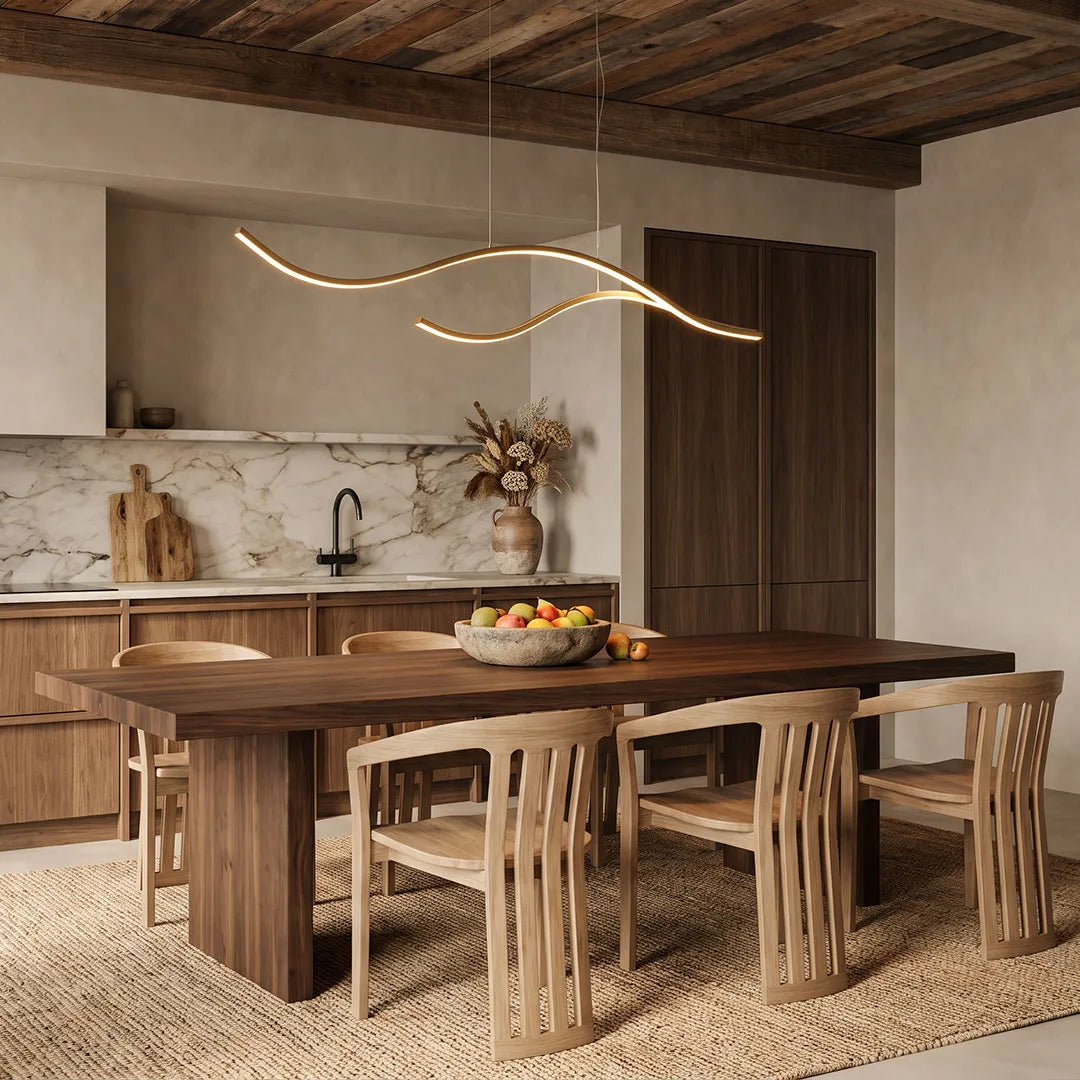 Linear pendant light made of wavy gold-coloured LED bars hung from a slim rectangular canopy above a wooden dining table.