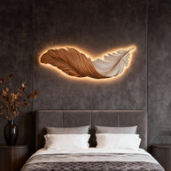 Comvilo Feather Wall Lamp in orange and white, mounted horizontally and lit above a bed