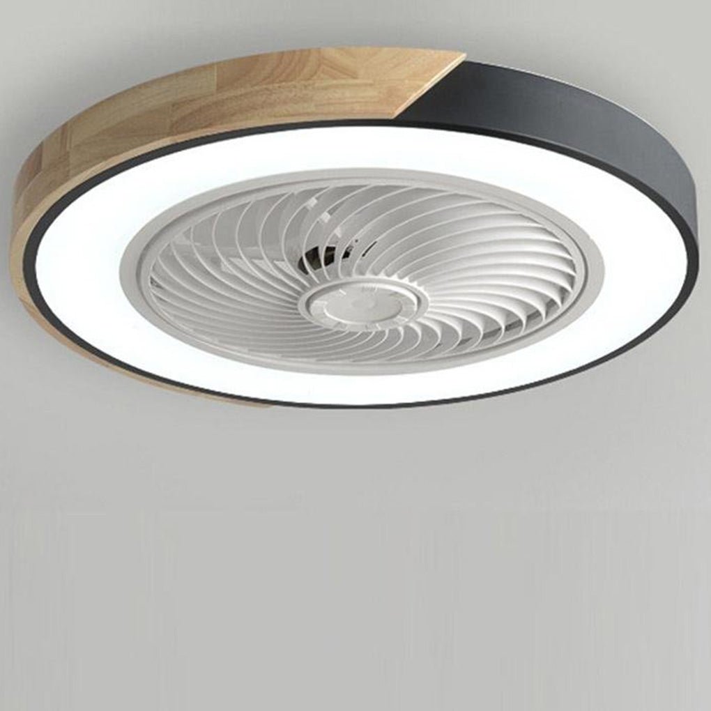 Round bladeless ceiling fan with light in black with a wood-grain section, light on, on a plain ceiling.
