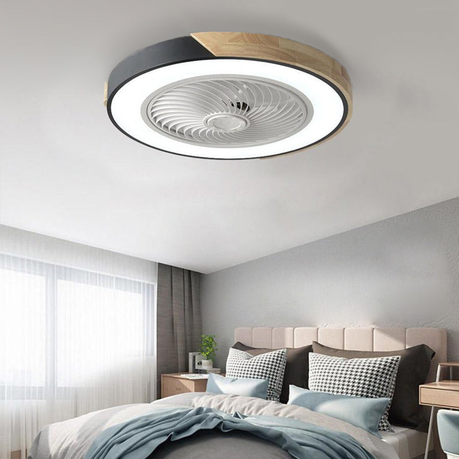 Round black and wood-grain bladeless ceiling fan with light, lit, on the ceiling of a bedroom with sheer curtains.