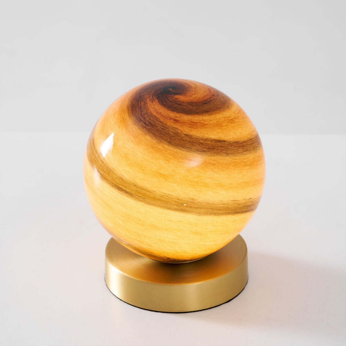 Globina Glass Globe Table Lamp, lit globe, three-quarter from above, brass base