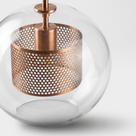 Close-up of the perforated copper drum and stem cap inside the clear glass sphere