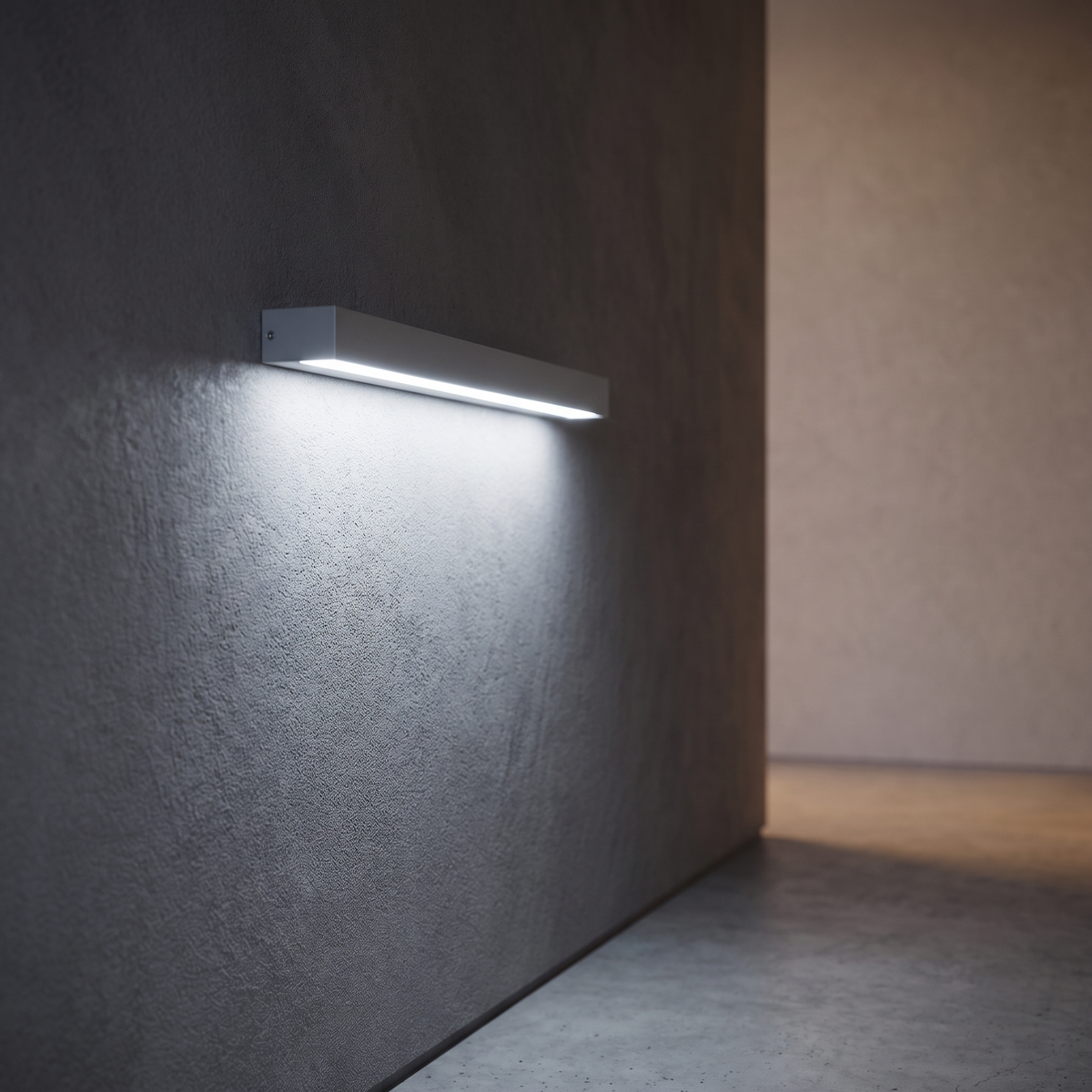 Volara dome LED wall light in grey, mounted at eye height on a dark plaster corridor wall, casting a beam down.