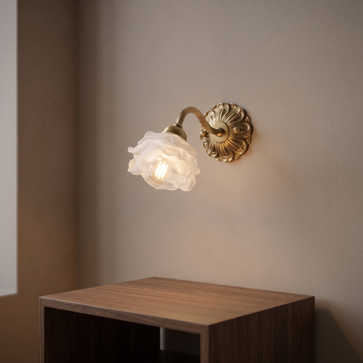 Thessane wall light with a brass rosette backplate, a curved fluted brass arm and a white ruffled rose-petal glass shade.