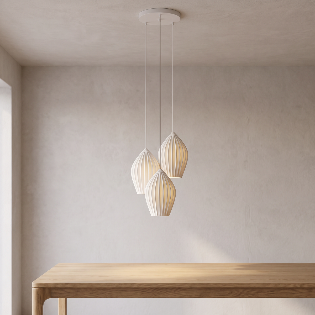 Elvenne pendant with three ribbed white ceramic shades on white cables from one round canopy, above an oak table.