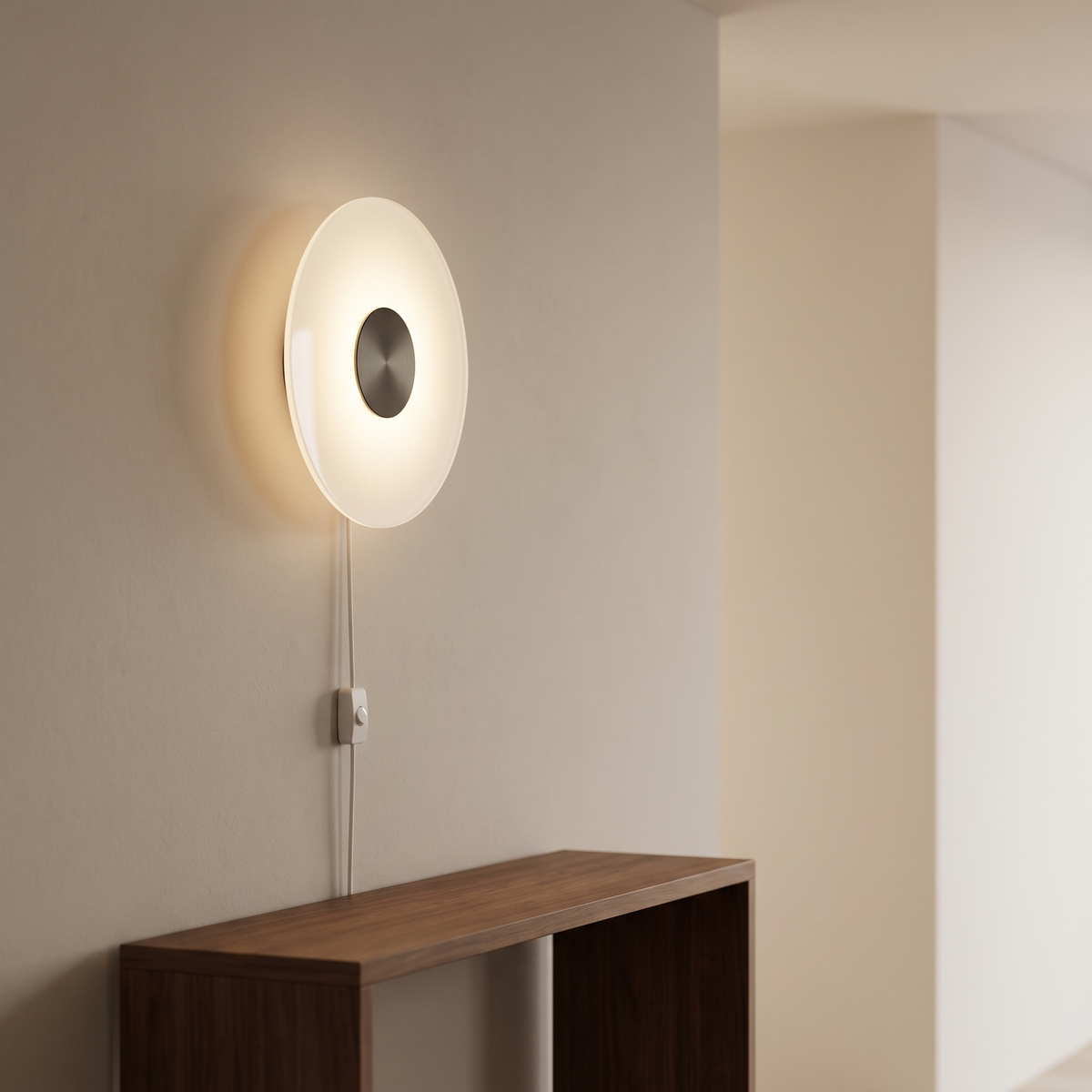 Tondelle wall sconce, a white lit disc with a dark metal centre, plugged in above a walnut console on a plain wall.