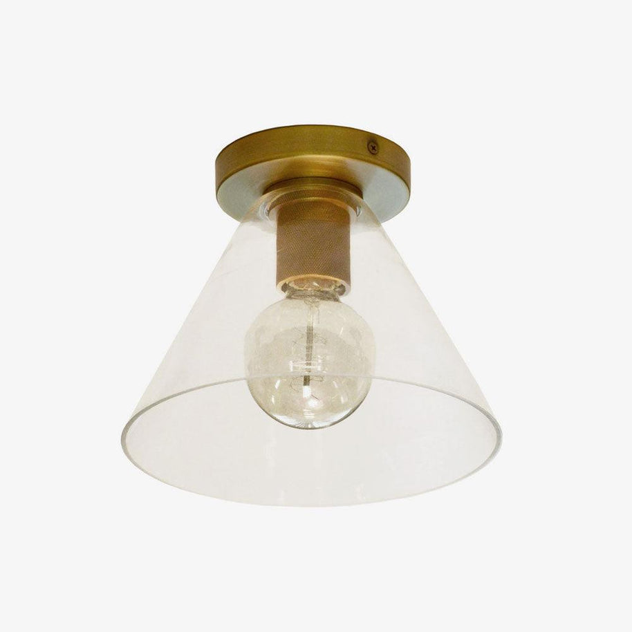Flush-mount ceiling light with a brass plate and clear cone-shaped glass shade, seen from below.