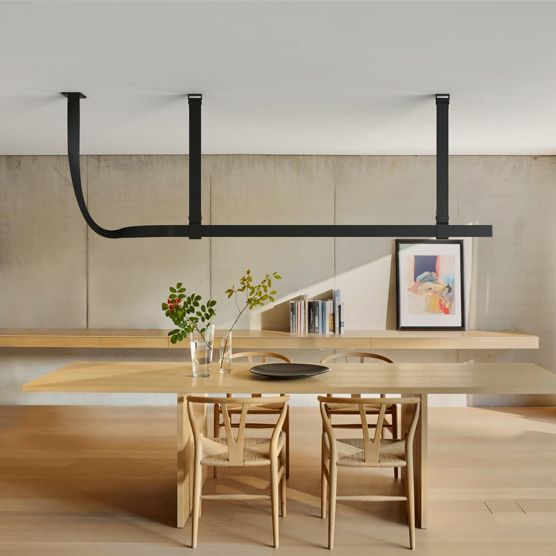 Maroven Linear Pendant Light in black with strap hangers above a wood dining table