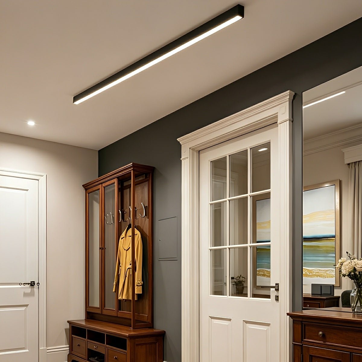 Slim linear LED ceiling light with a black body, fitted along a hallway ceiling.
