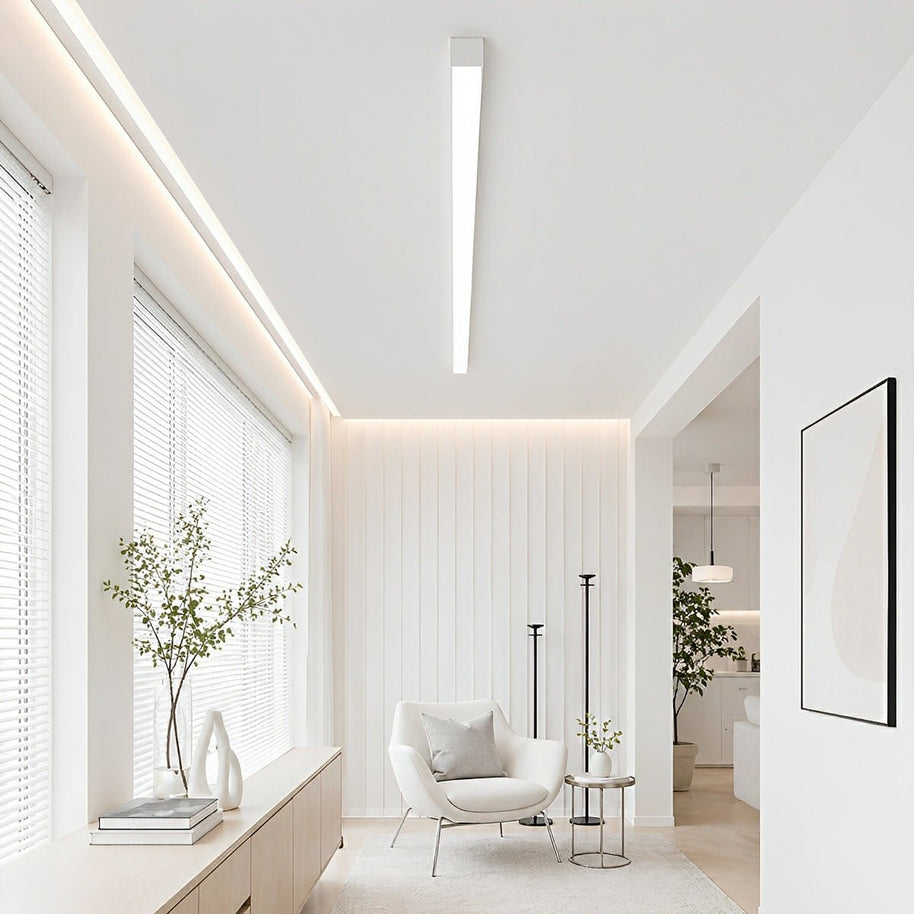 Slim linear LED ceiling light with a white body, fitted across a ceiling in a bright sitting room.