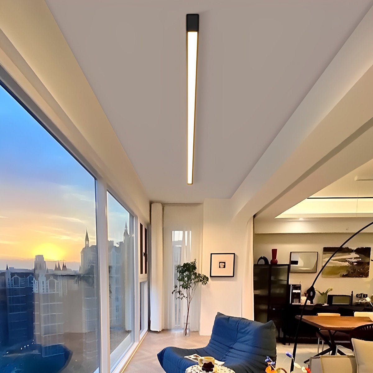 Slim linear ceiling light fitted along the ceiling of an open-plan room with a sunset view.