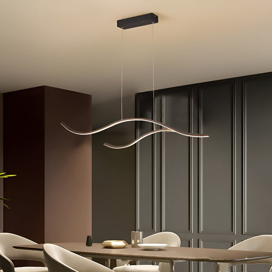 Linear pendant light made of wavy LED bars hung from a slim rectangular canopy, lit, above a dining table in a room with dark panelling.