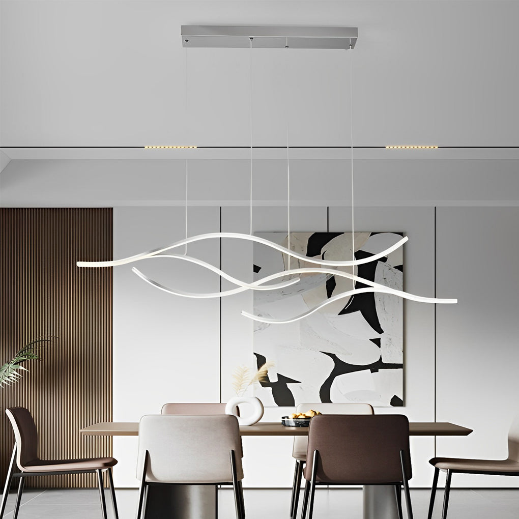 Linear pendant light made of wavy chrome-coloured LED bars hung from a slim rectangular canopy above a dining table in front of a mural.