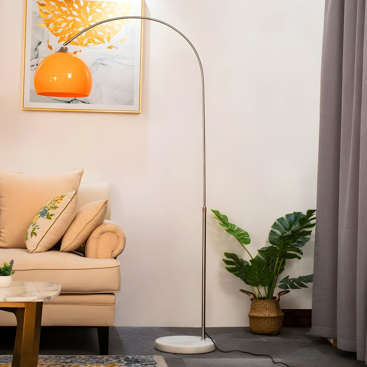 Orienne Arch Floor Lamp with orange dome shade arching over a beige sofa in a living room