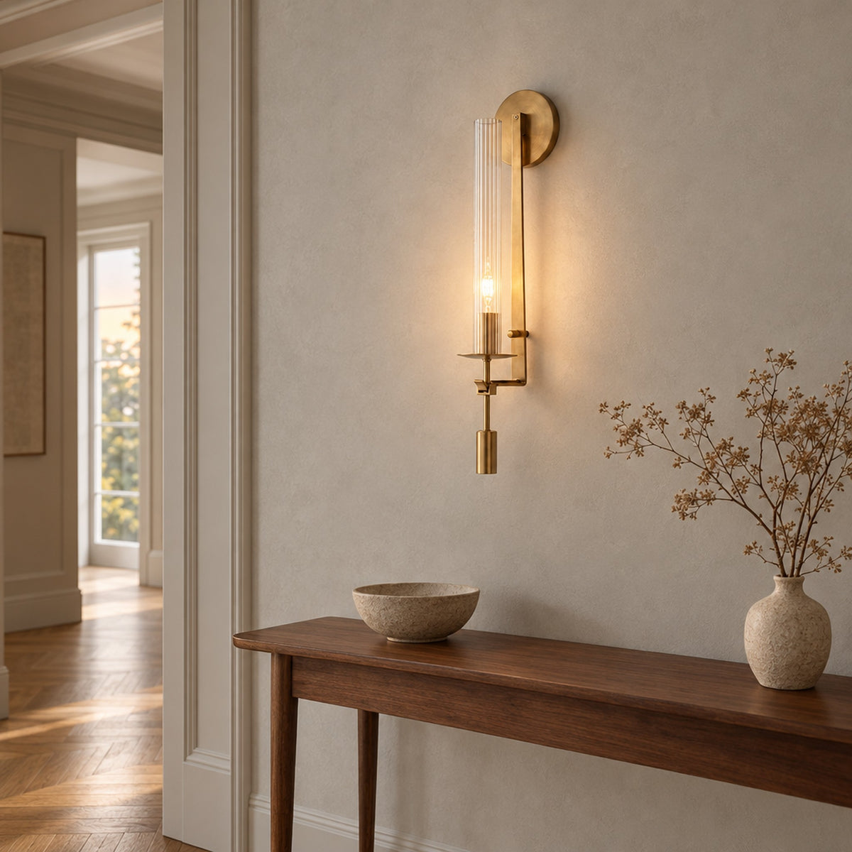 Valenne Ribbed Glass Wall Sconce, lit above a walnut console in an entry hallway