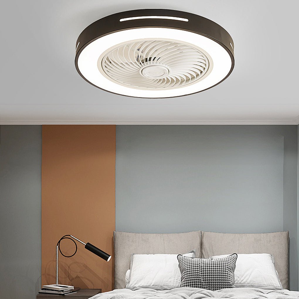 Flush-mount ceiling fan with an enclosed blade cage and a lit ring, black outer rim, fitted to a bedroom ceiling above a bed.