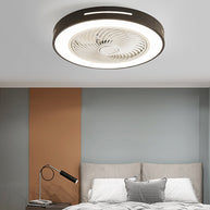 Flush-mount ceiling fan with an enclosed blade cage and a lit ring, black outer rim, fitted to a bedroom ceiling above a bed.