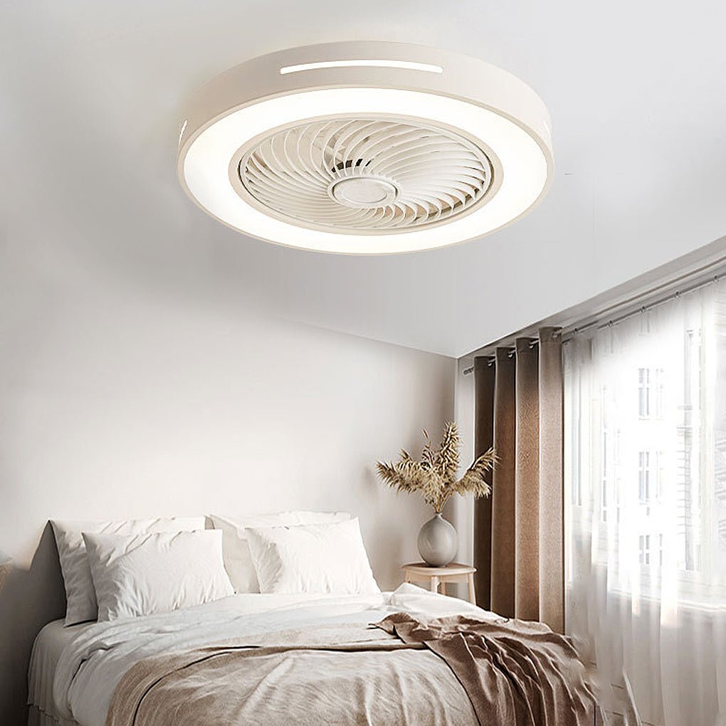 Flush-mount ceiling fan with an enclosed blade cage and a lit ring, white outer rim, fitted to a bedroom ceiling above a bed.