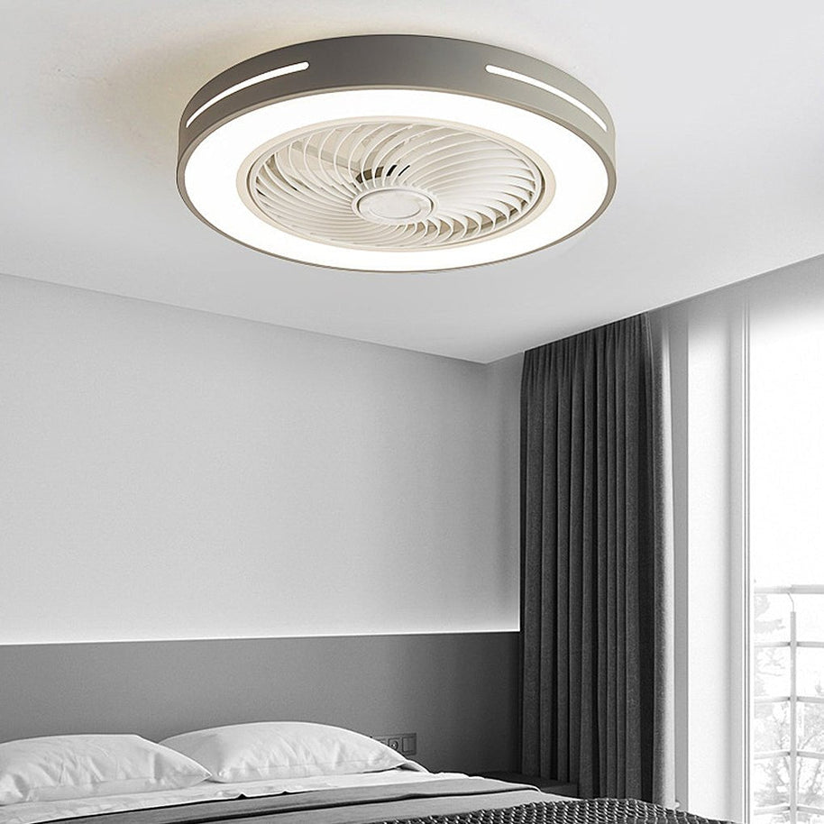 Flush-mount ceiling fan with an enclosed blade cage and a lit ring, grey outer rim, fitted to a bedroom ceiling above a bed.