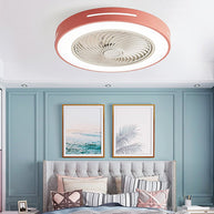 Flush-mount ceiling fan with an enclosed blade cage and a lit ring, pink outer rim, fitted to a bedroom ceiling above a bed with framed prints behind.