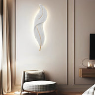 Feather White Resin LED Wall Light in white, above a seating area